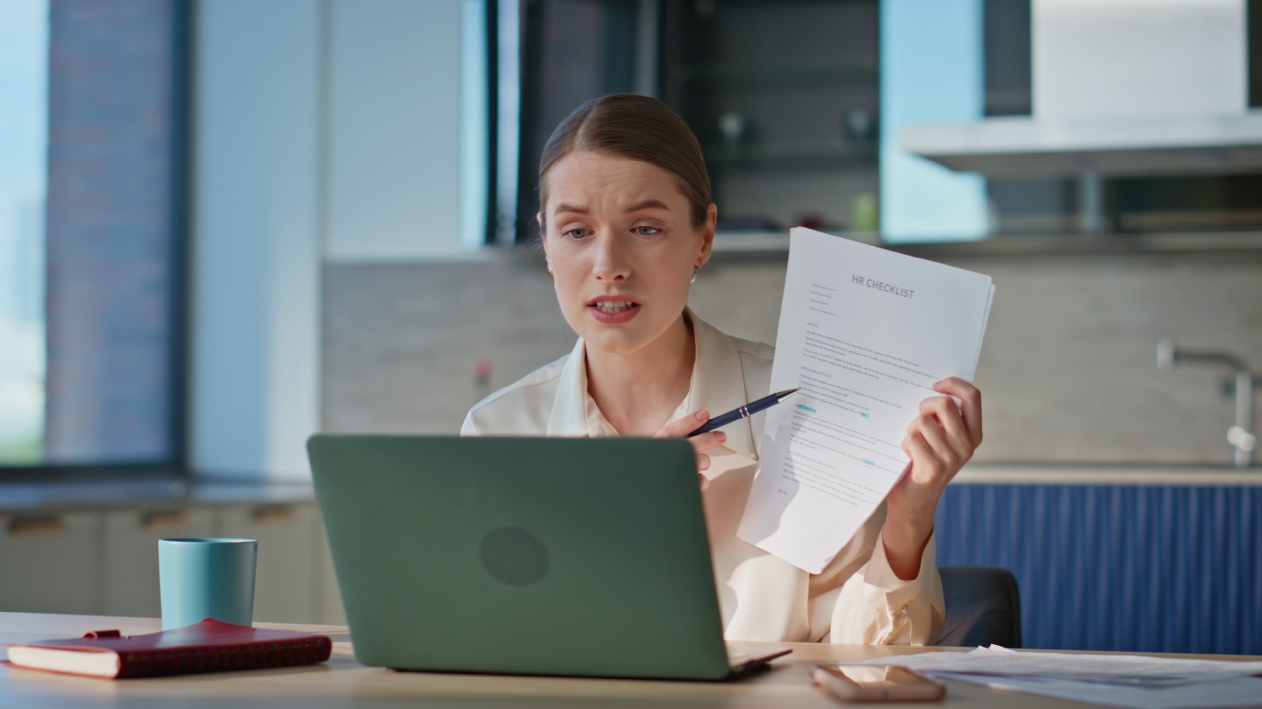 Online tutor showing papes to laptop webcam sitting modern kitchen closeup.